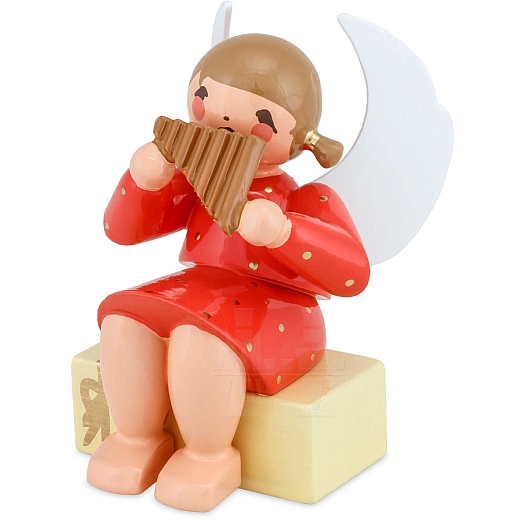 Engel sitzend auf Geschenkpaket mit Panflöte rot